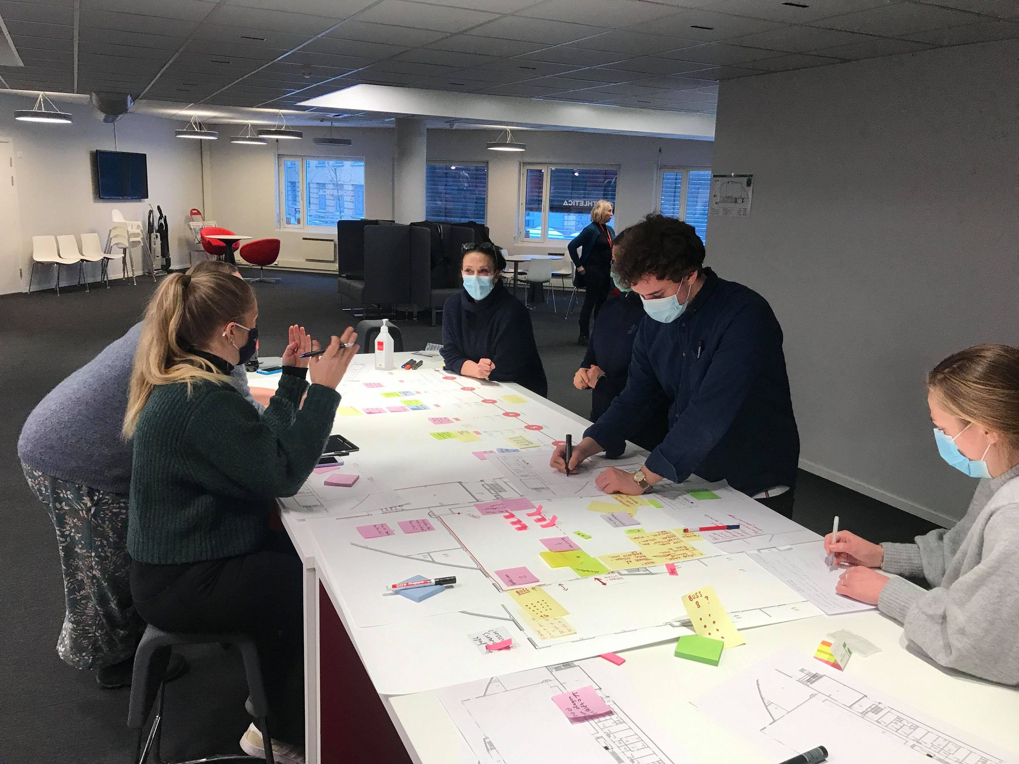 Gruppen jobber med plantegninger og post-it-lapper